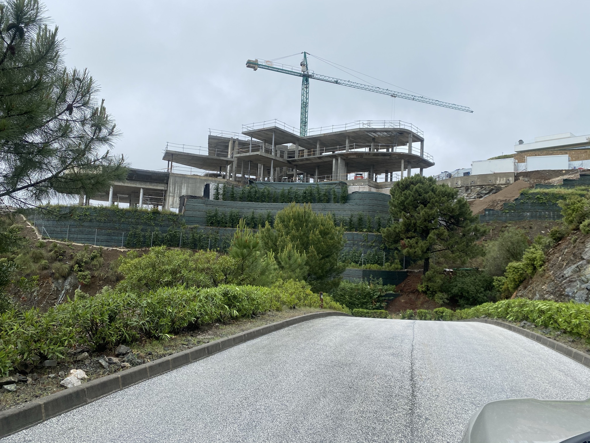 Image shows crane over the shell of a luxury villa construction.