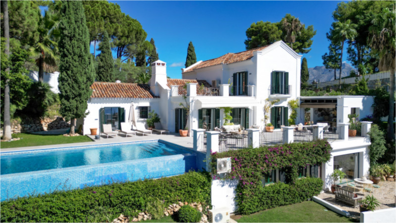 Luxury villa in El Madroñal, Benahavís, featuring a private pool, lush gardens, and elegant architecture.