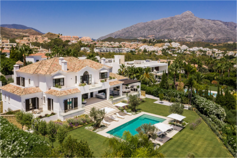 Aerial view of the luxury villa in La Cerquilla, Nueva Andalucia, surrounded by gardens and panoramic mountain views.